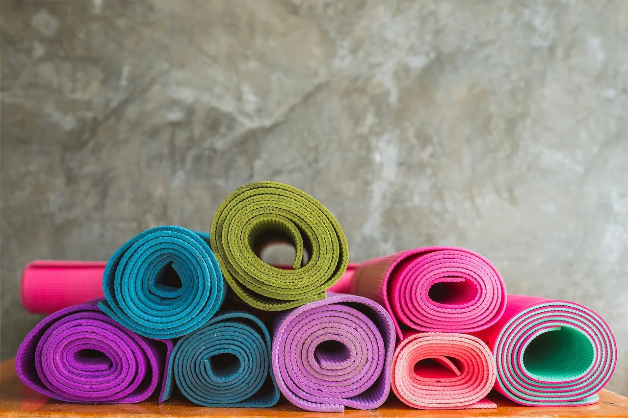 A pile of colorful yoga MATS neatly stacked on top of each other