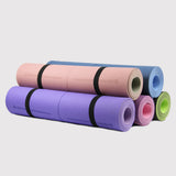 A vibrant set of colorful yoga mats rolled and ready for use, featuring various hues such as purple, pink, and green, sold by Sportive Lives in Canada.