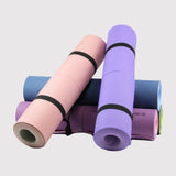 Group of multi-colored yoga mats rolled and stacked together, available in different tones, representing Sportive Lives' eco-friendly yoga products in Canada.