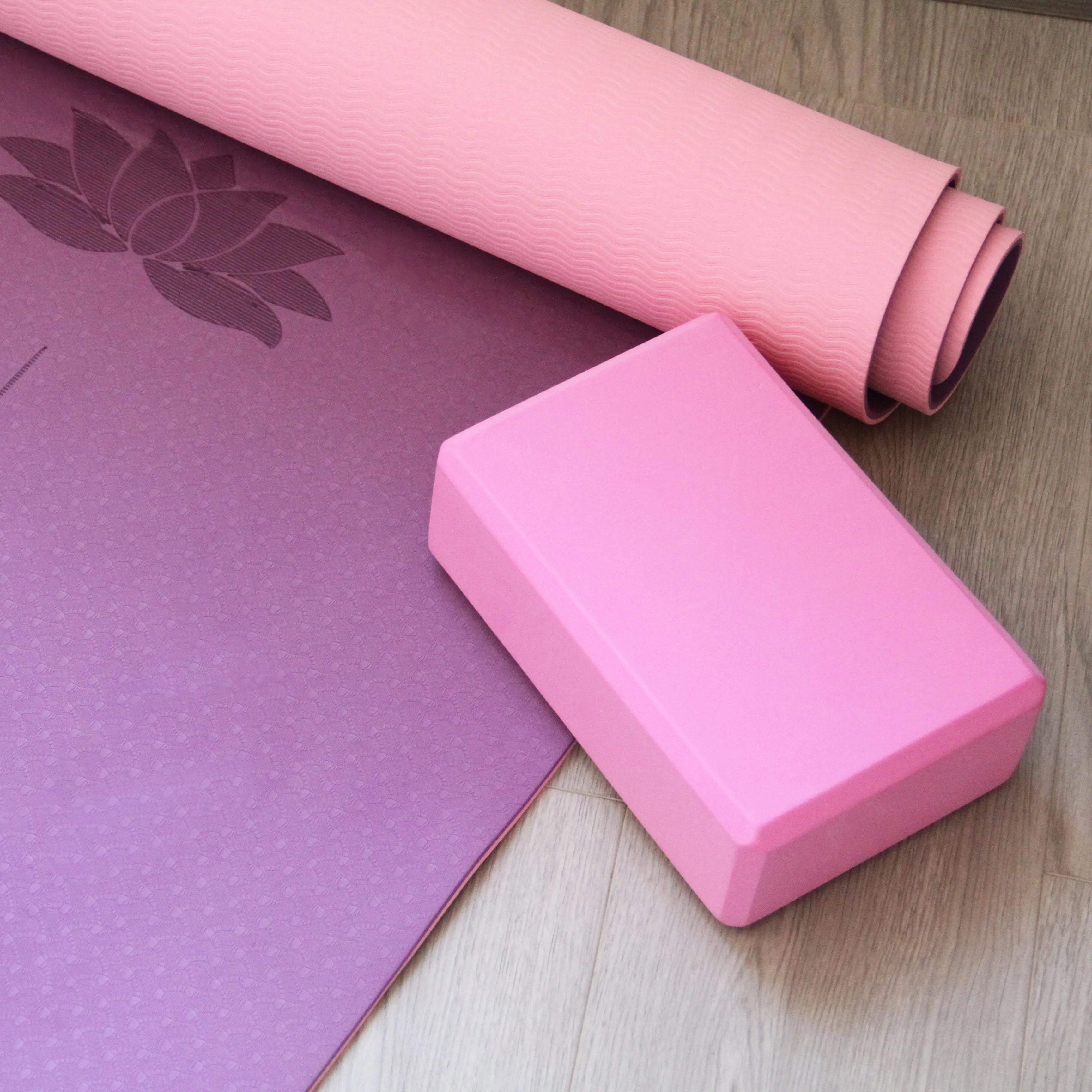 Pink yoga block paired with a purple and pink yoga mat, providing excellent support during yoga routines. Available at Sportive Lives in Canada.