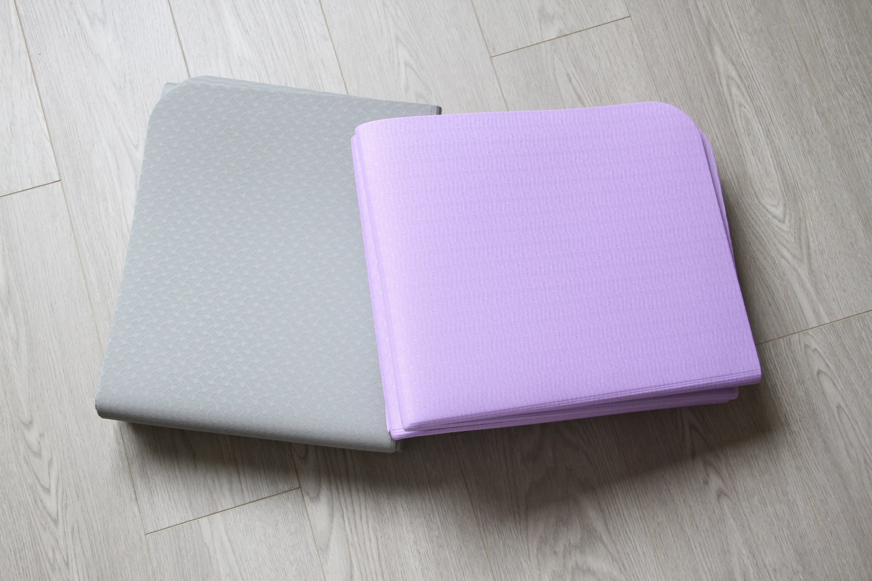 Gray and purple portable folding yoga mats, designed for convenience and portability. Available at Sportive Lives in Canada.