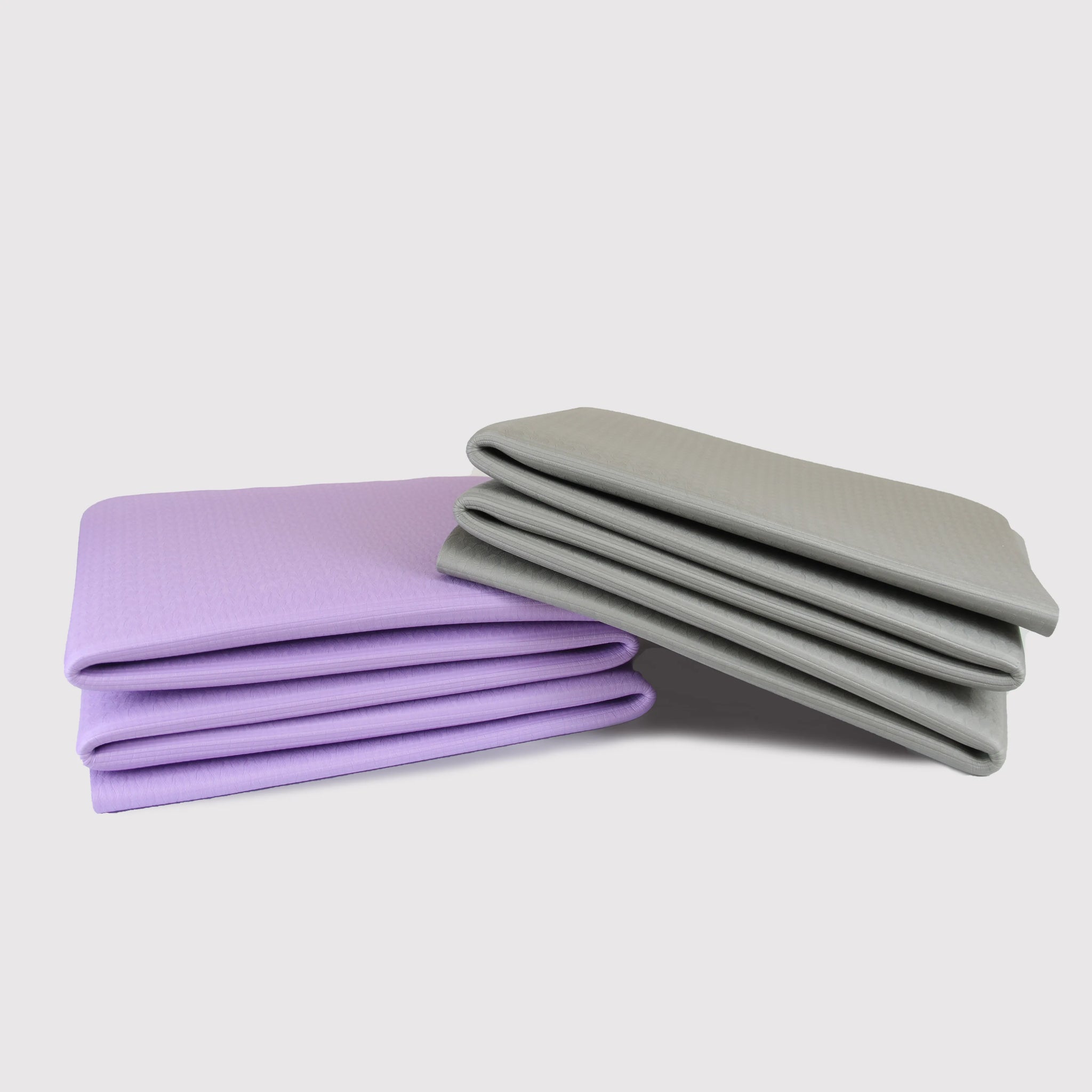 Sportive Lives foldable yoga mats in purple and gray, stacked for compact storage, perfect for yoga practice and travel in Canada.