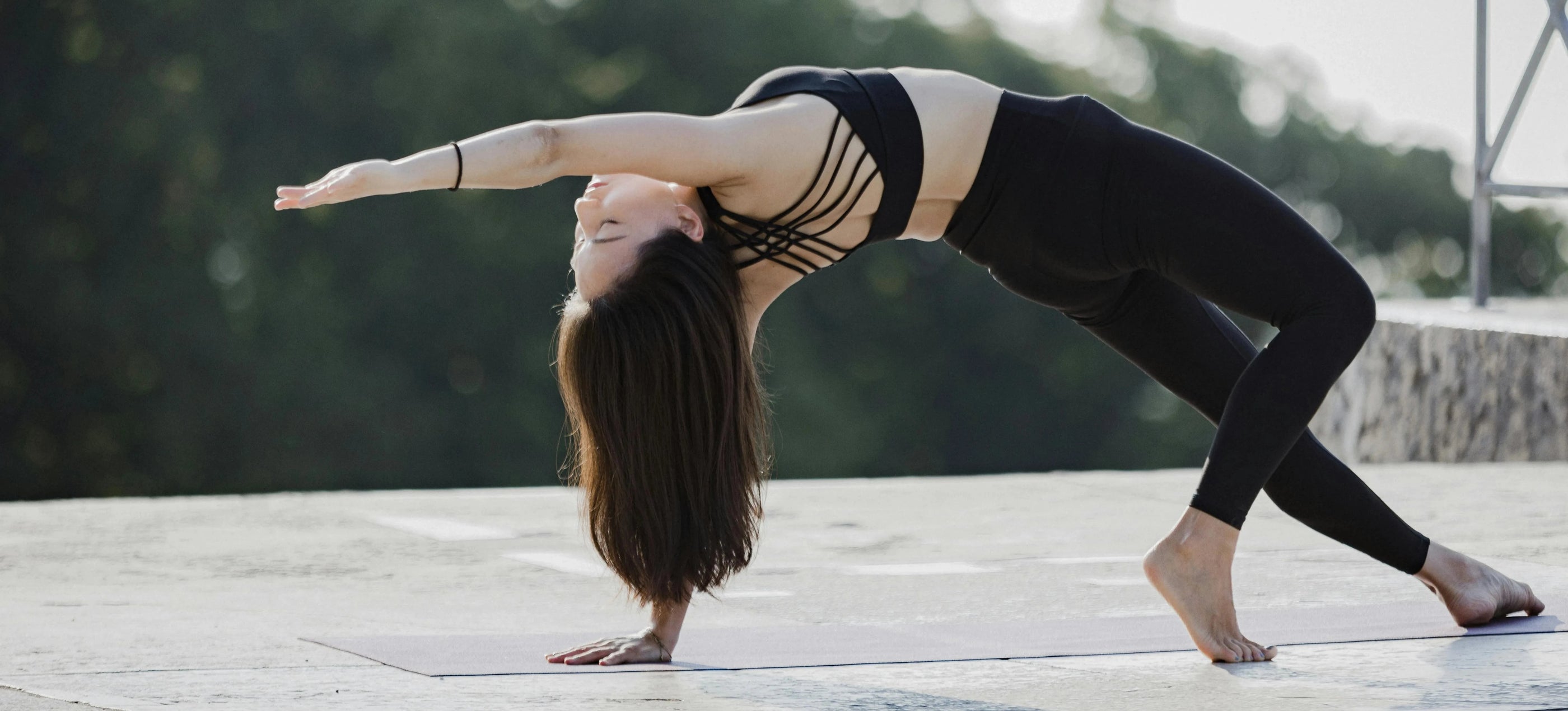 Sportive Lives yoga practitioner performing Wild Thing Pose (Camatkarasana) outdoors, perfect for enhancing balance and strength.